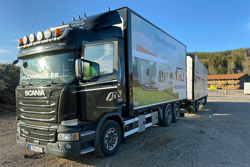 Lastbil med släp som levererar ett Hudikhus
