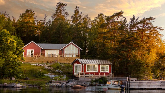 Rött h-format hus med vita knutar i serien Torekov på en ö